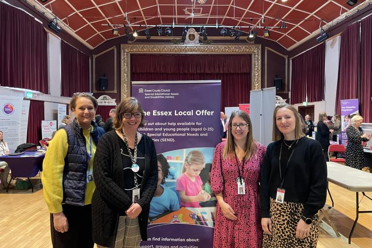 4 send professionals standing around a reception desk at a roadshow