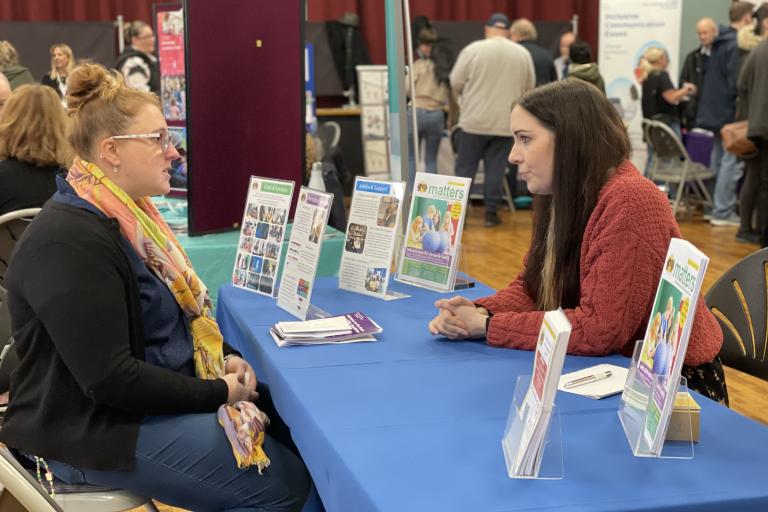 A parent and sitting at a table receiving advice 